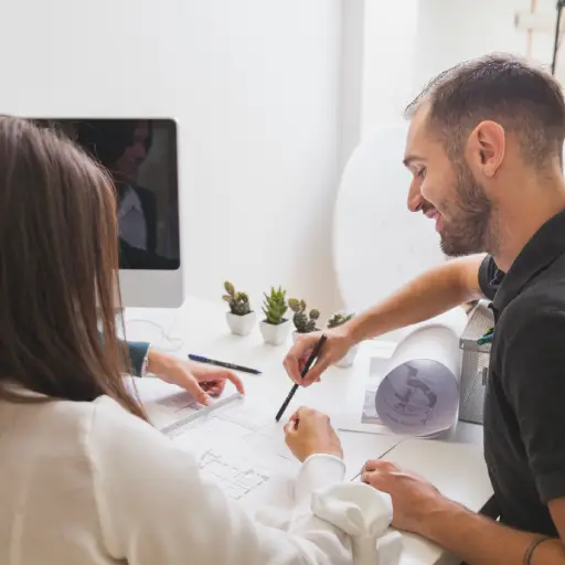 Compañeros analizando un plano sobre arquitectura